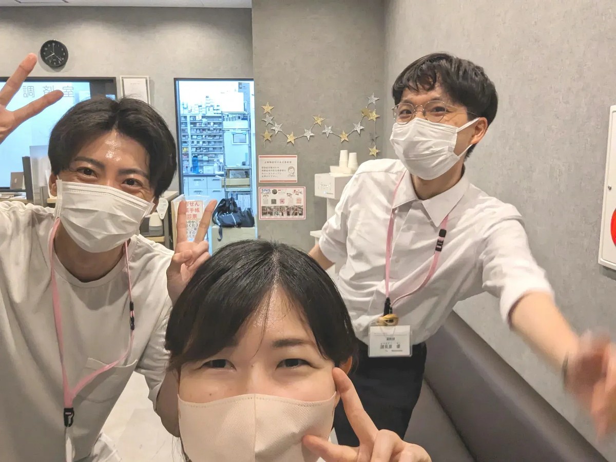 まんまる薬局 CB目黒の調剤室でメンバーと写る皆川卓也さん