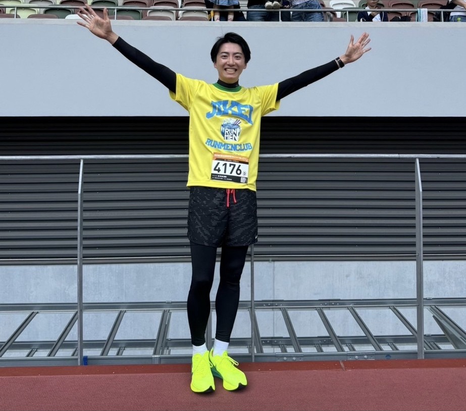 マラソンを完走し両手を広げる皆川卓也さん