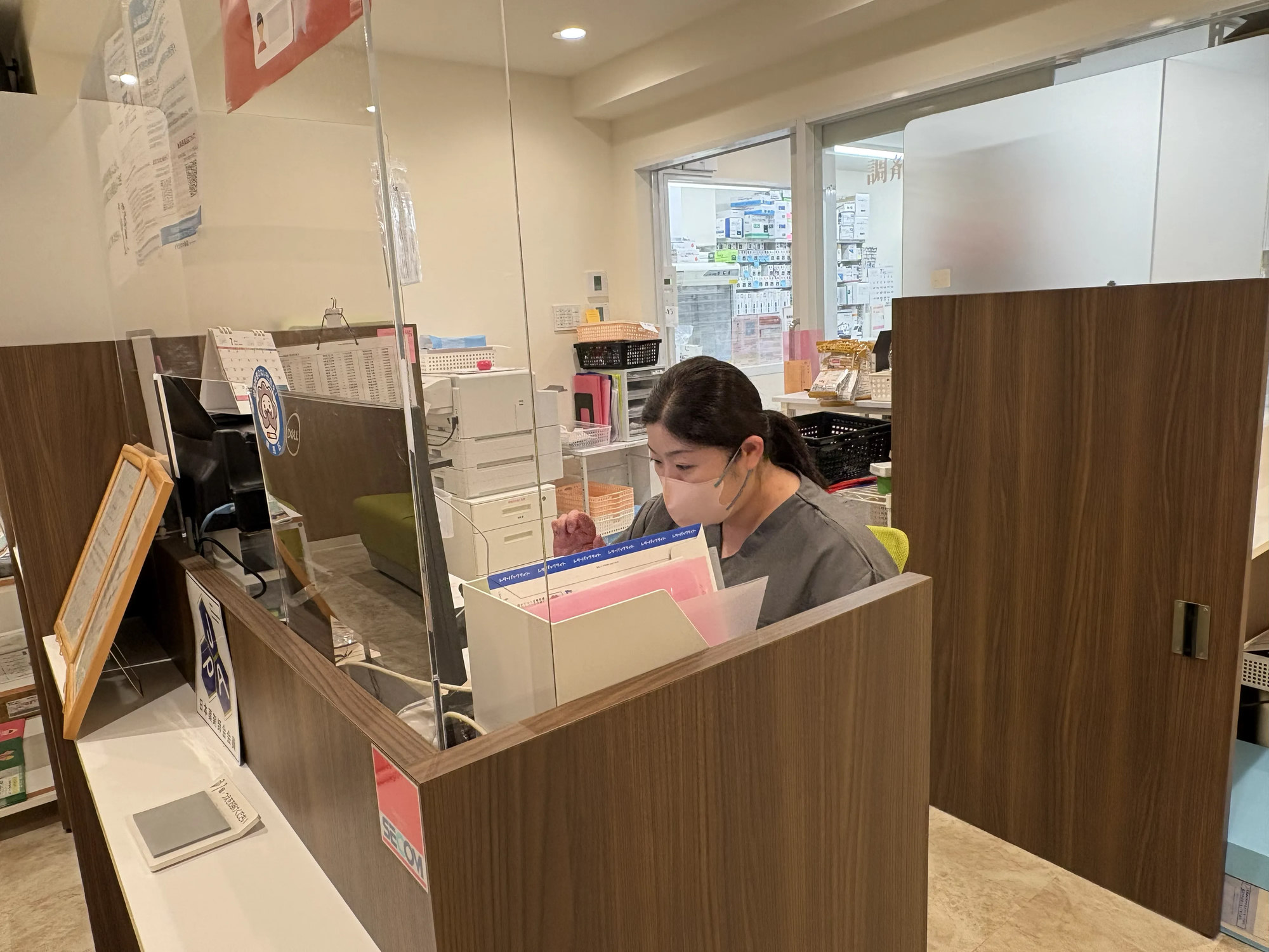 受付カウンターで業務にあたる森さん|まんまる薬局 OMF光が丘